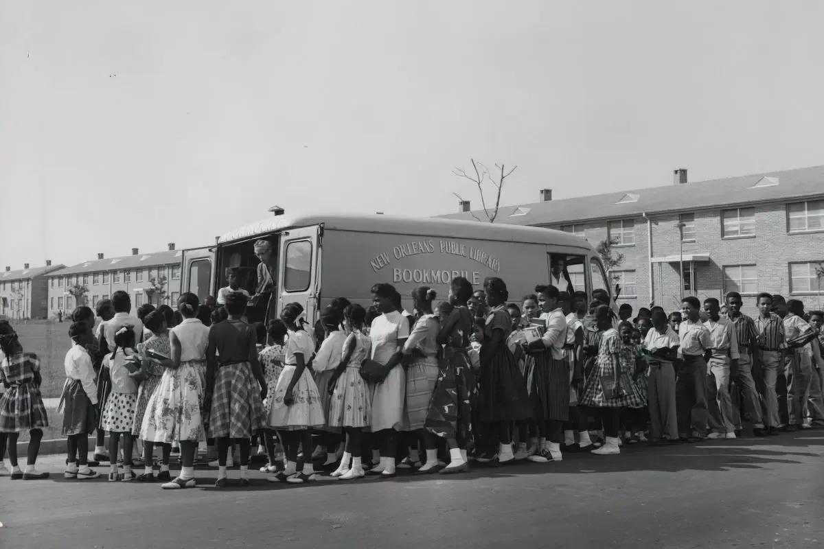 Archival photo of children lining up at a bookmobile in the Desire community, New Orleans